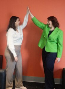 two women giving a high five. successful event